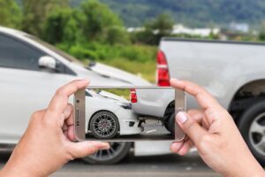Driver taking photo of a car accident in Austin as evidence.