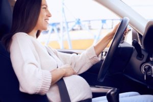 Pregnant woman is driving on her way home.