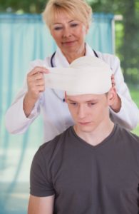 Doctor putting bandage on head injury after an accident.