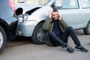 Man calling for first aid after car accident.