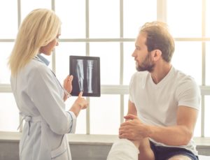 Injured man consulting doctor over xray results.