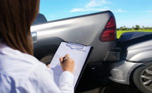 Car insurance agent thoroughly inspecting car damages.