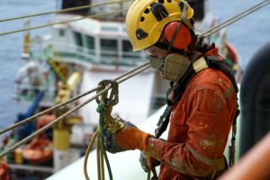 An abseiler wearing personal protective equipment preparing for work.