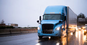 Blue semi-truck driving on Houston, TX highway
