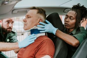 Paramedics rescuing injured driver from car accident.